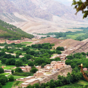 High Atlas Mountains - Majestic mountain range overlooking lush green valley with palm trees and bright blue sky